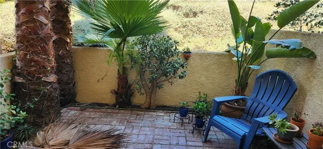 a view of patio with table and chairs and potted plants
