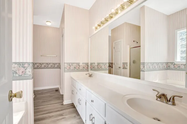 a spacious bathroom with a tub sink and mirror