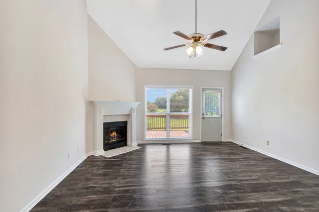 a view of a livingroom with a ceiling fan fireplace and wooden floor