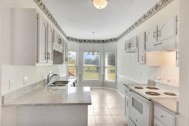 a kitchen with stainless steel appliances granite countertop a sink stove and cabinets