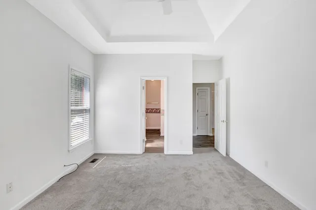 a view of an empty room with window and closet area