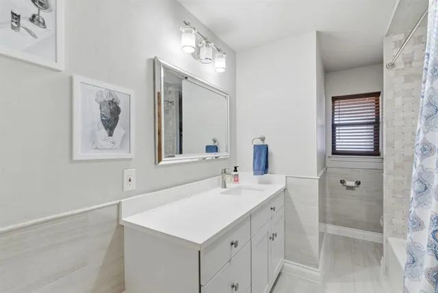 a bathroom with a sink vanity granite tub and shower