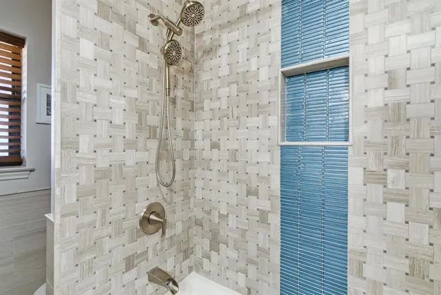a view of a hallway with wooden floor and a bathroom