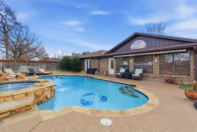a view of swimming pool with outdoor seating and yard in the back