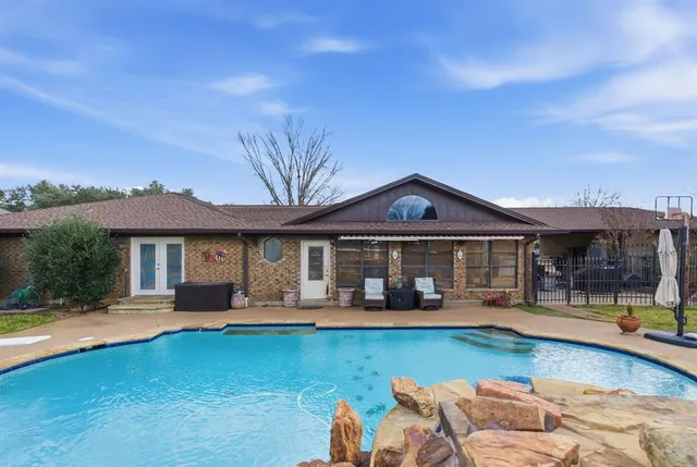 a front view of a house with swimming pool having outdoor seating
