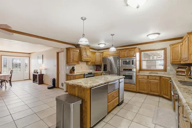 a kitchen with stainless steel appliances granite countertop a stove a sink dishwasher and a refrigerator