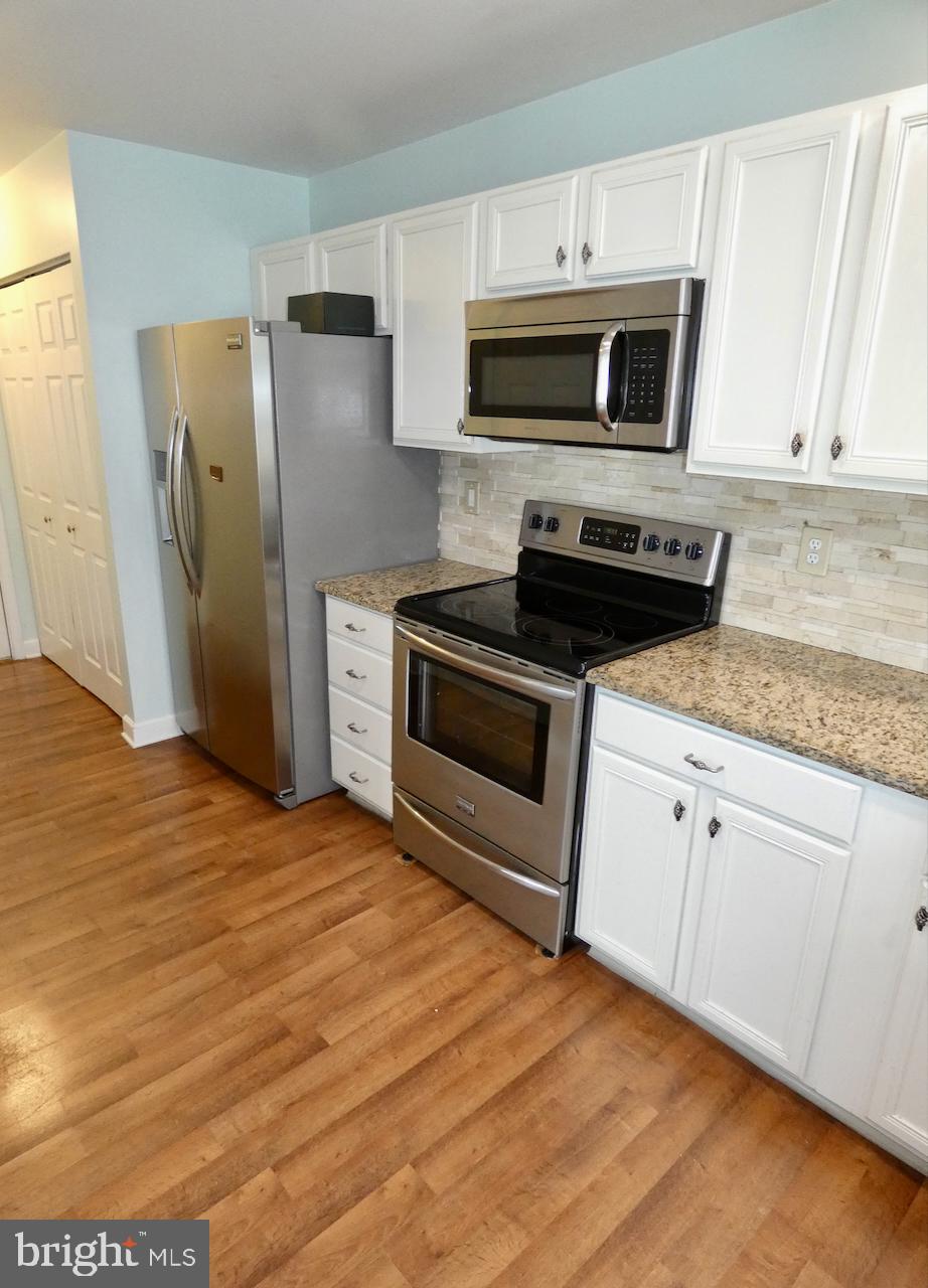 335 Marldale Drive Middletown, DE 19709 - Photo 24 of 58 a kitchen with granite countertop a refrigerator stove and microwave