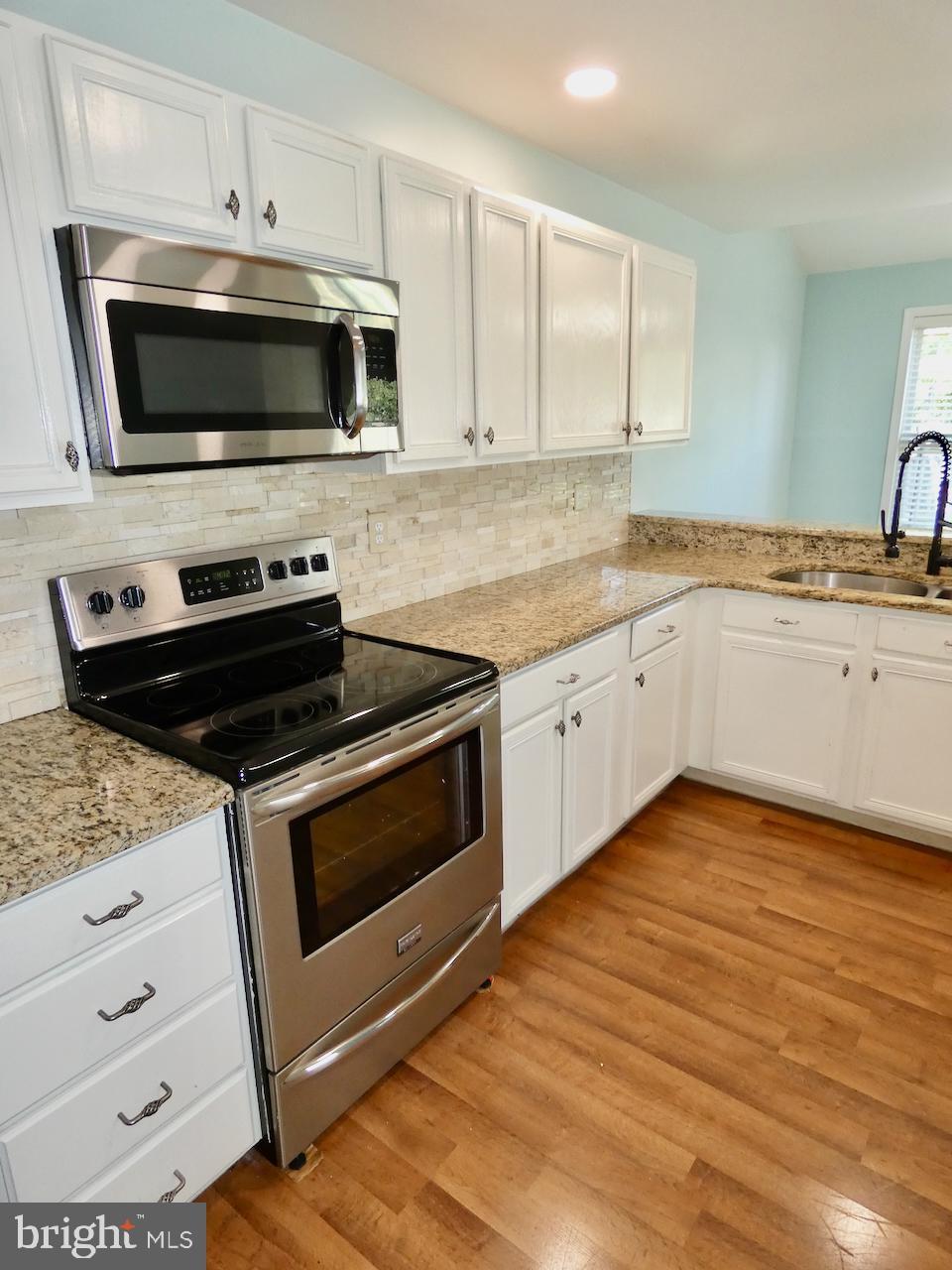 335 Marldale Drive Middletown, DE 19709 - Photo 28 of 58 a kitchen with granite countertop a stove microwave and sink