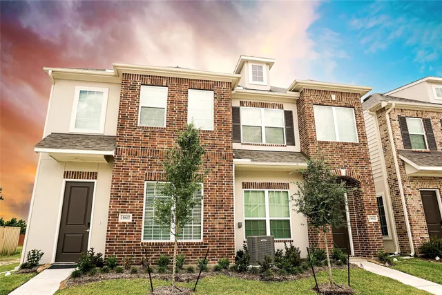 front view of a brick house with a yard