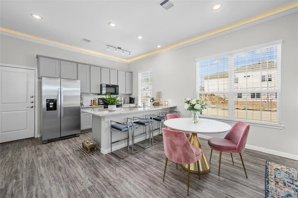 a kitchen with a table chairs refrigerator and cabinets