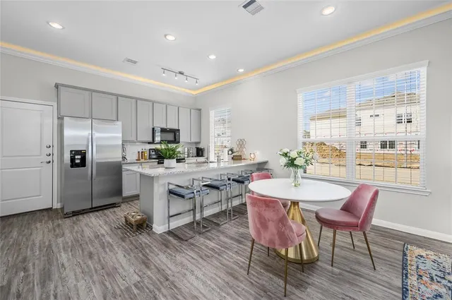 a kitchen with a table chairs refrigerator and cabinets