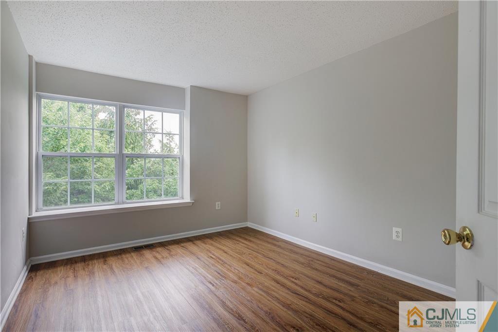 53 Prestwick Way Edison, NJ 08820 - Photo 18 of 28 an empty room with wooden floor and windows