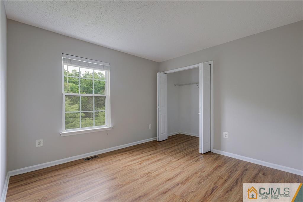 53 Prestwick Way Edison, NJ 08820 - Photo 19 of 28 an empty room with wooden floor and windows