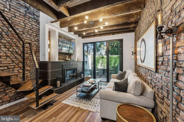 a living room with furniture a fireplace and a floor to ceiling window
