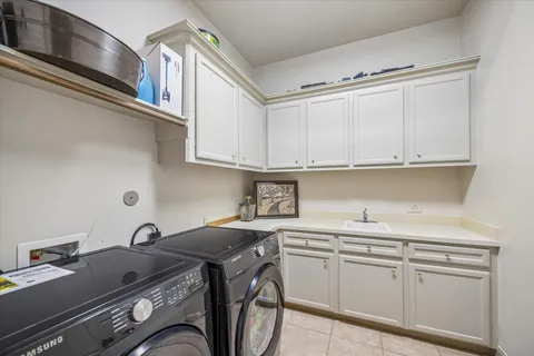a utility room with stainless steel appliances granite countertop a sink and a stove next to a refrigerator