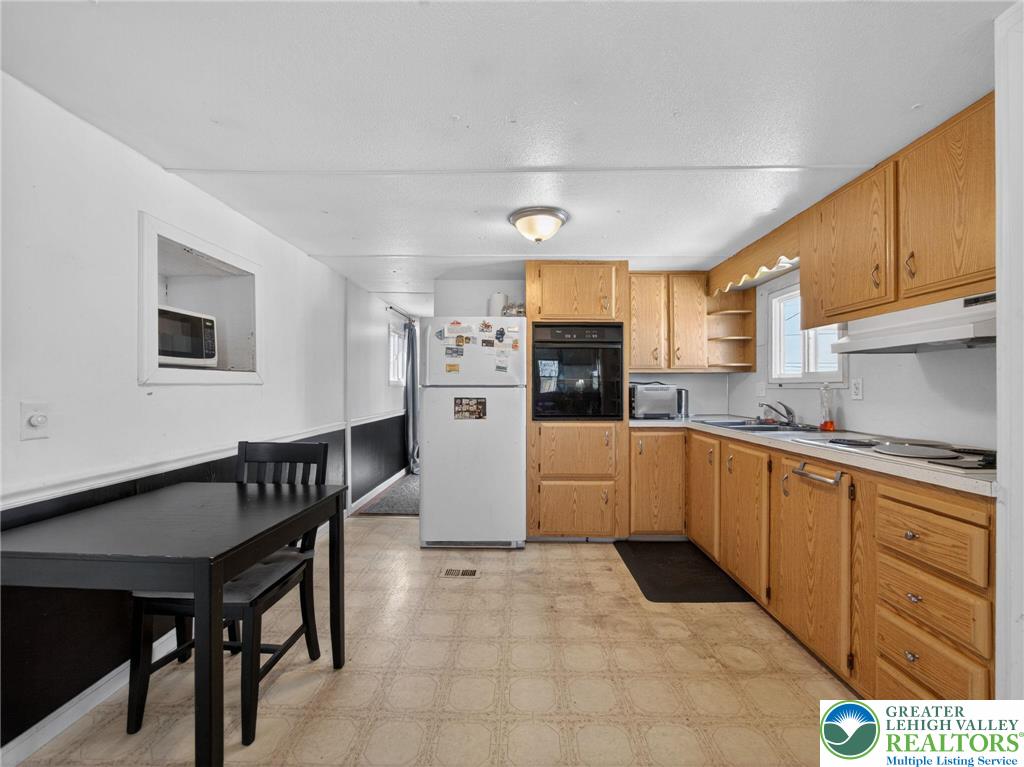 23 Roth Avenue Mertztown, PA 19539 - Photo 17 of 29 a kitchen with stainless steel appliances kitchen island granite countertop a table chairs sink and cabinets