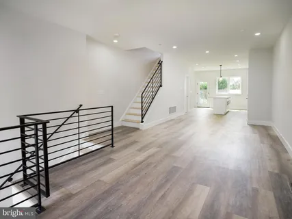 a view of a hallway with wooden floor and staircase