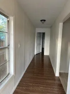 a view of a hallway with wooden floor