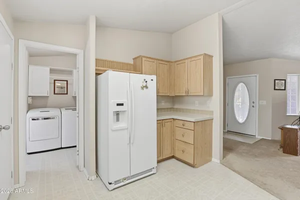 a open kitchen with white cabinets and white appliances