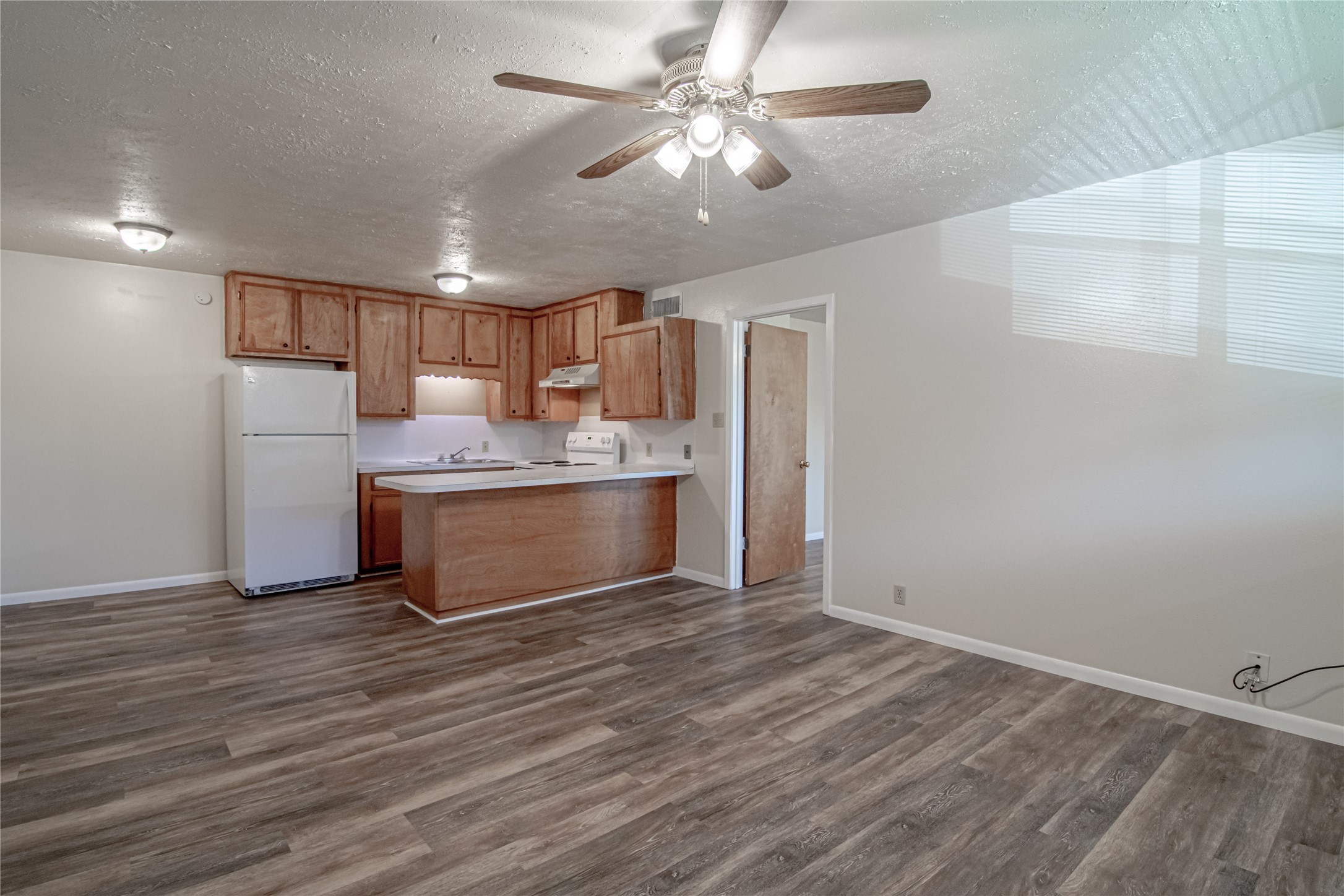 120 McAdams Lane, Unit F Huntsville, TX 77320 - Photo 4 of 21 a kitchen with stainless steel appliances granite countertop a sink a stove a refrigerator cabinets and wooden floor