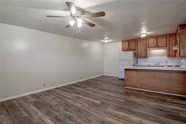 a view of kitchen with granite countertop cabinets and wooden floor