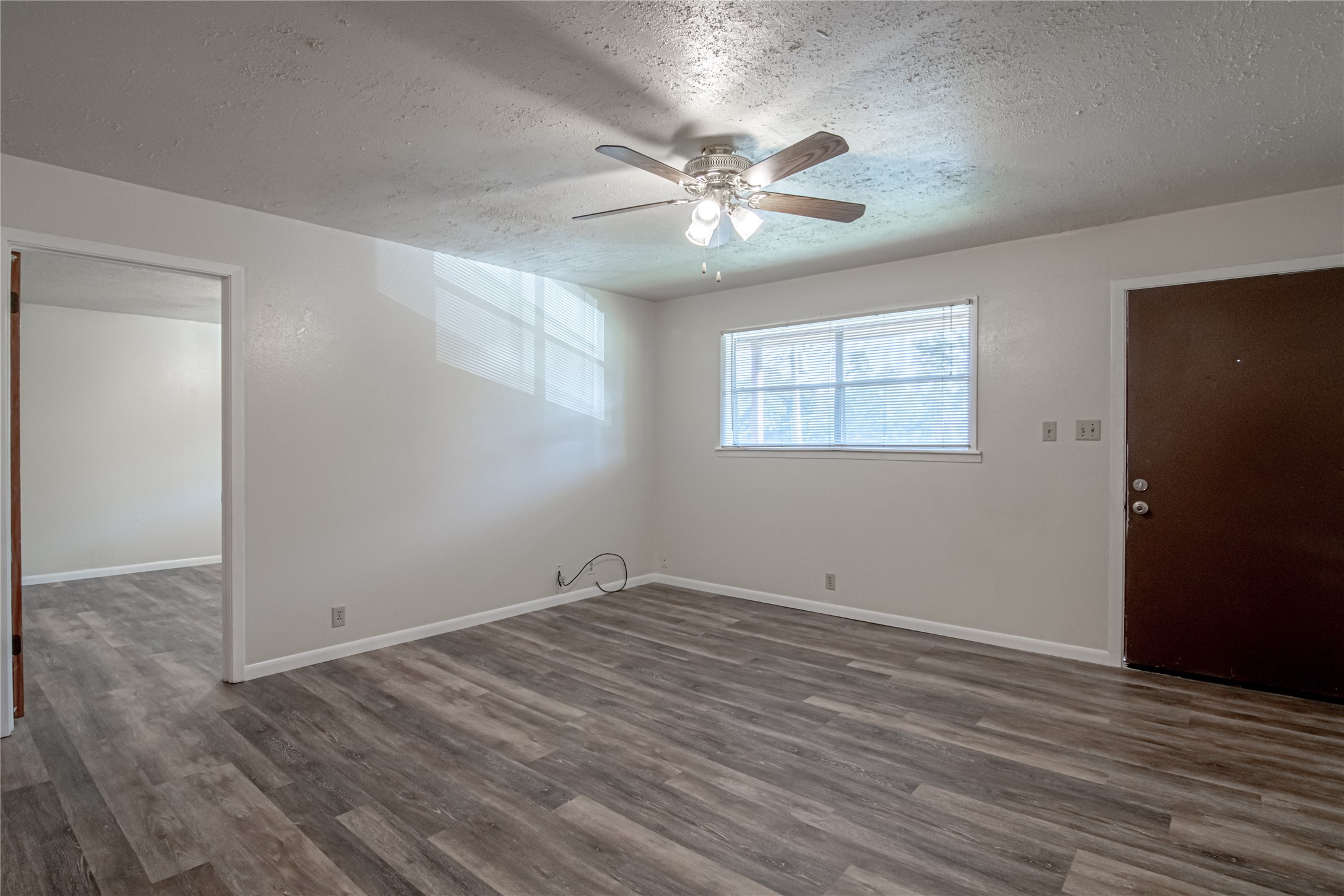 120 McAdams Lane, Unit F Huntsville, TX 77320 - Photo 7 of 21 a view of an empty room with wooden floor and a window