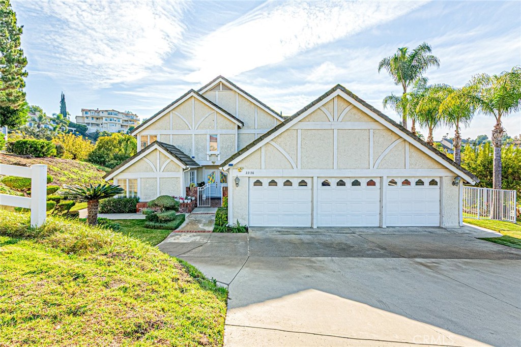 a view of a house with a yard and potted plants