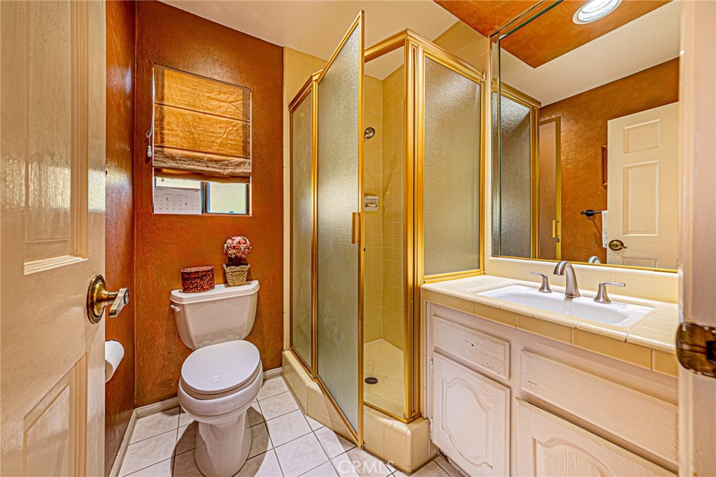22138 Rim Fire Lane Diamond Bar, CA 91765 - Photo 39 of 61 a bathroom with a granite countertop sink toilet and shower