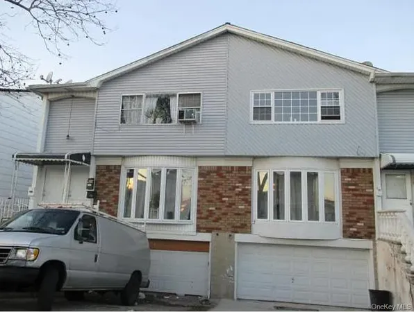 a view of a house with a cars park side of a road