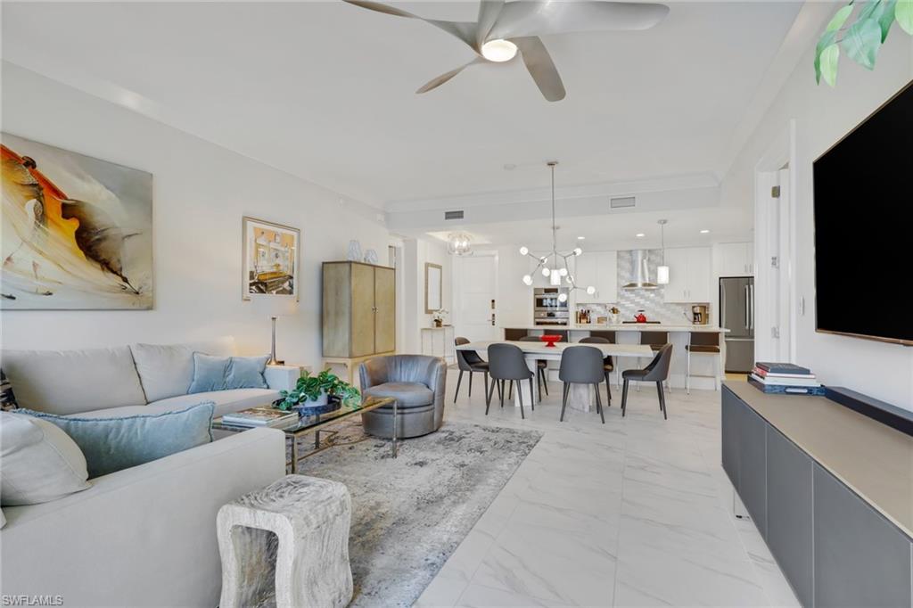 1135 3rd Avenue South, Unit 403 Naples, FL 34102 - Photo 10 of 34 Living area featuring ceiling fan, light marble finish flooring, and a chandelier
