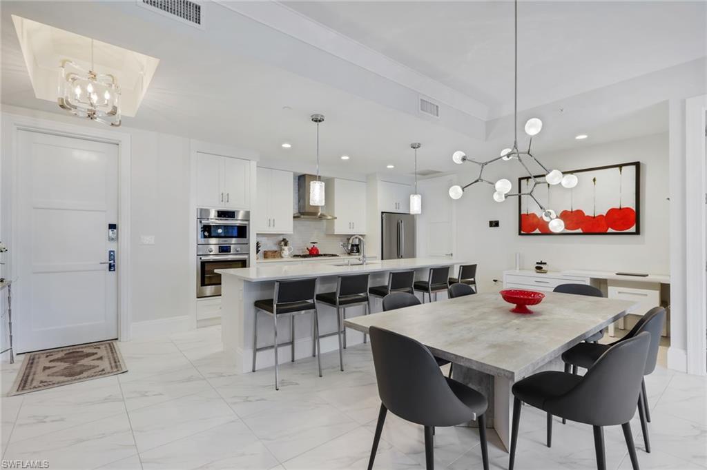1135 3rd Avenue South, Unit 403 Naples, FL 34102 - Photo 2 of 34 Dining space with hanging lights and light marble finish floors
