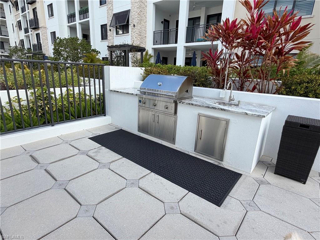 1135 3rd Avenue South, Unit 403 Naples, FL 34102 - Photo 25 of 34 View of patio with an outdoor kitchen and a sink