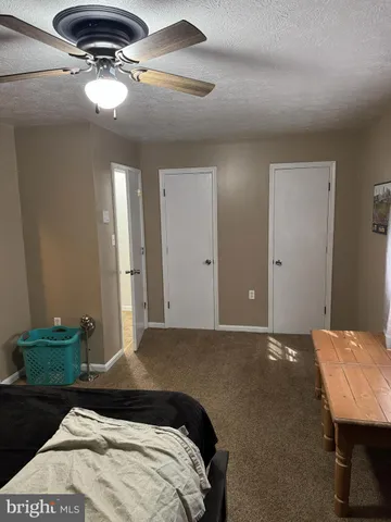 a bedroom with a bed and ceiling fan