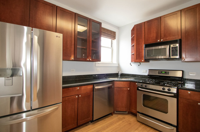 Undisclosed Address Oak Park, IL 60302 - Photo 15 of 18 a kitchen with granite countertop a refrigerator stove and microwave