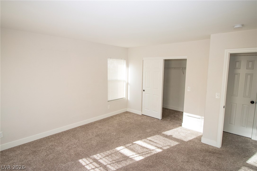 1468 Reef Ridge Court Las Vegas, NV 89128 - Photo 11 of 22 A well-lit bedroom featuring ample closet space and plush carpeting.