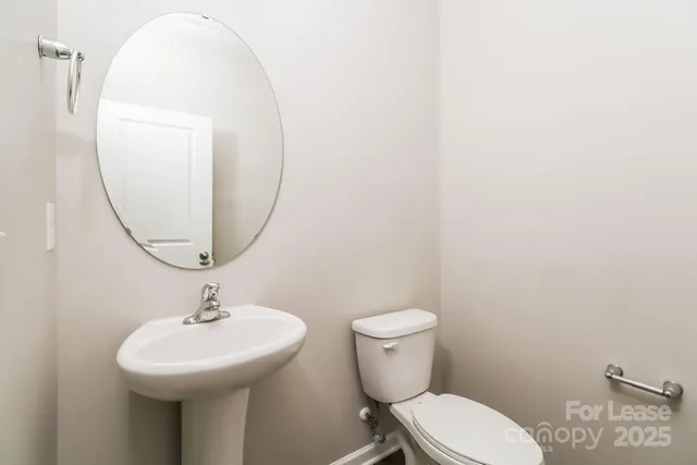 a bathroom with a toilet a sink and a mirror