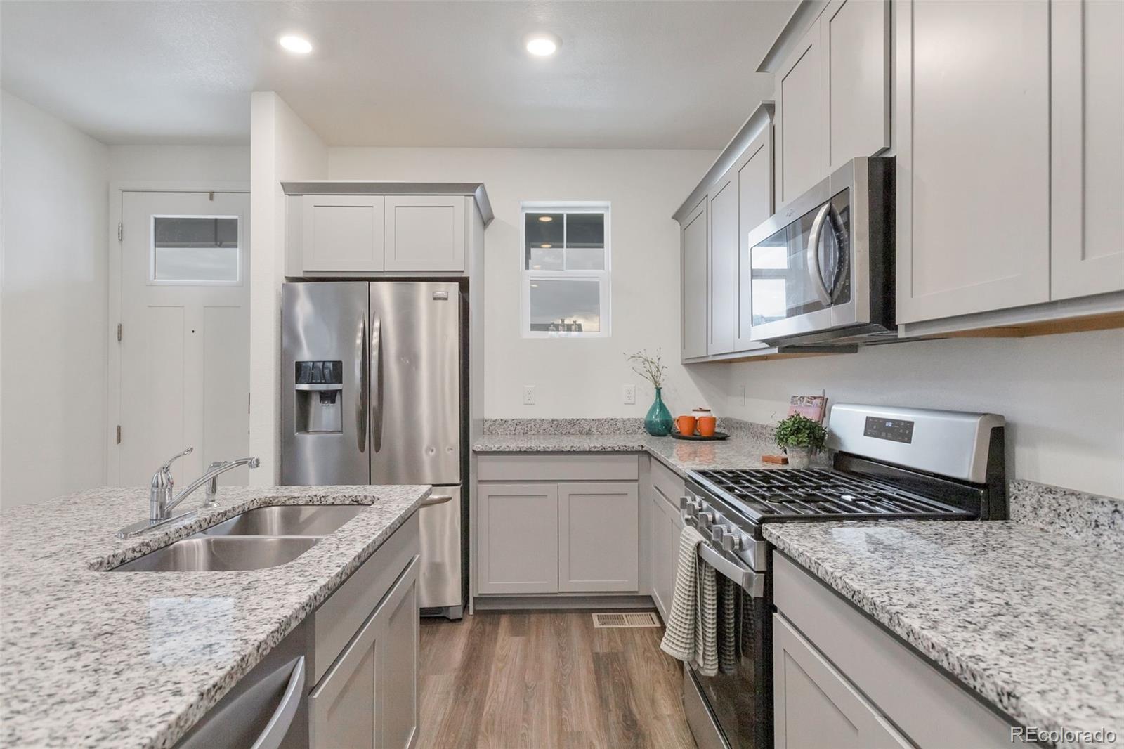 7017 Kali Court Frederick, CO 80530 - Photo 5 of 15 a kitchen with stainless steel appliances granite countertop a sink stove and refrigerator