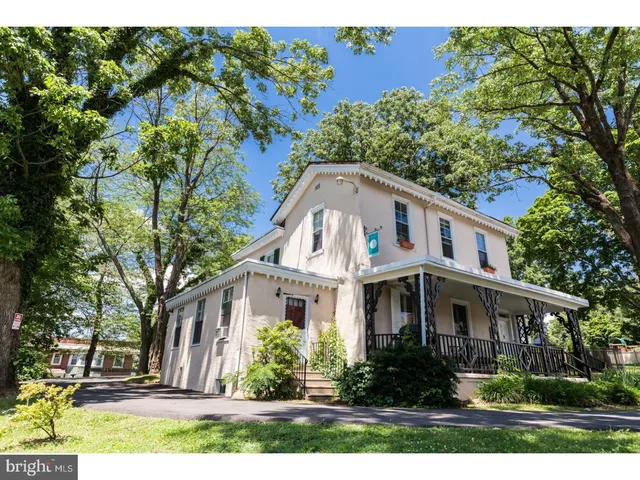 a front view of a house with a yard and trees