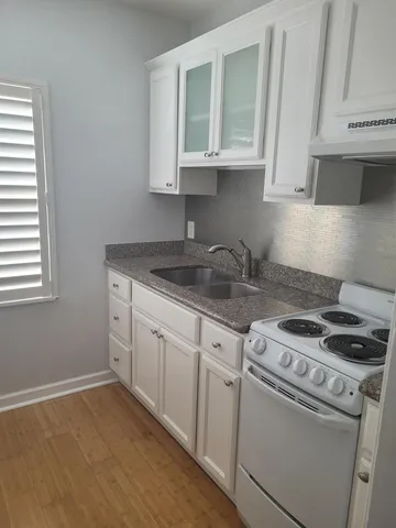 a kitchen with granite countertop white cabinets and white appliances