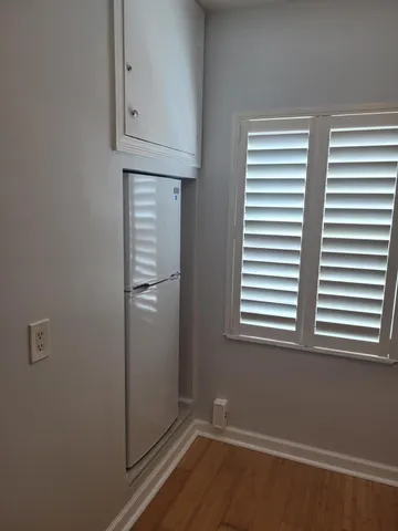 an empty room with wooden floor and a window