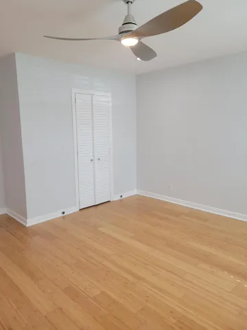 a view of an empty room and chandelier fan
