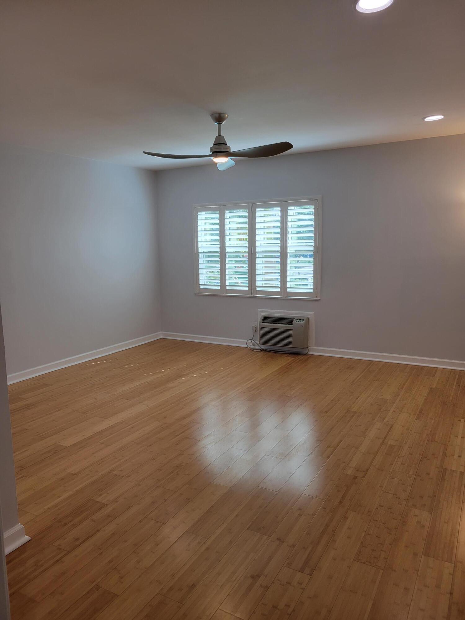 101 South Golfview Road, Unit 11 Lake Worth Beach, FL 33460 - Photo 10 of 28 an empty room with wooden floor and windows