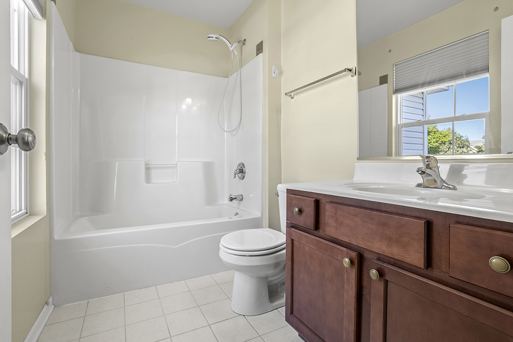 6506 Roth Drive Joliet, IL 60431 - Photo 19 of 24 a bathroom with a granite countertop sink a toilet and shower
