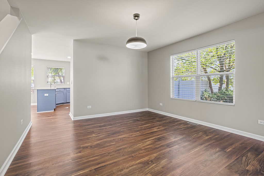 6506 Roth Drive Joliet, IL 60431 - Photo 6 of 24 an empty room with wooden floor cabinet and windows