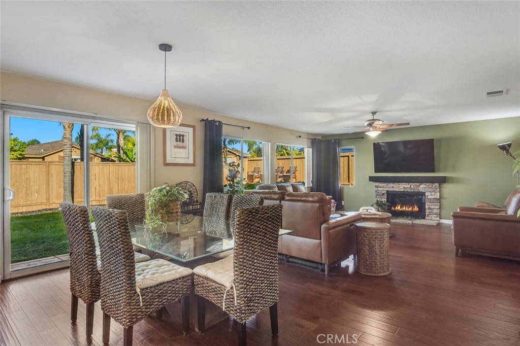 4330 Forest Ranch Way Oceanside, CA 92057 - Photo 12 of 51 The dining area is highlighted by a custom light fixture, while a glass slider invites in natural light and backyard views, blurring the line between indoors and out.