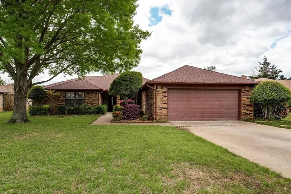 a front view of a house with a garden and yard