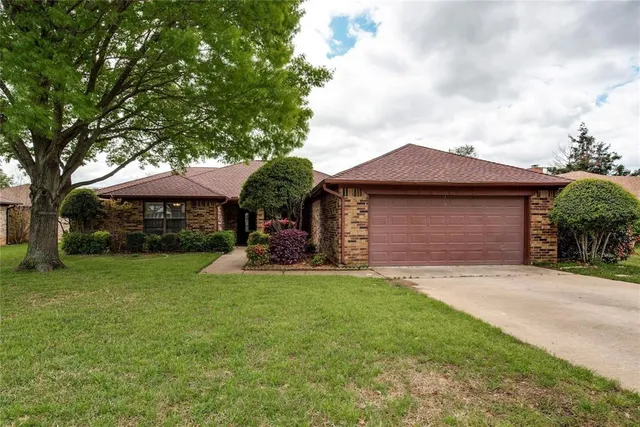 a front view of a house with a garden and yard