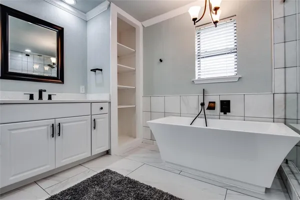a spacious bathroom with a double vanity sink a mirror and a bathtub