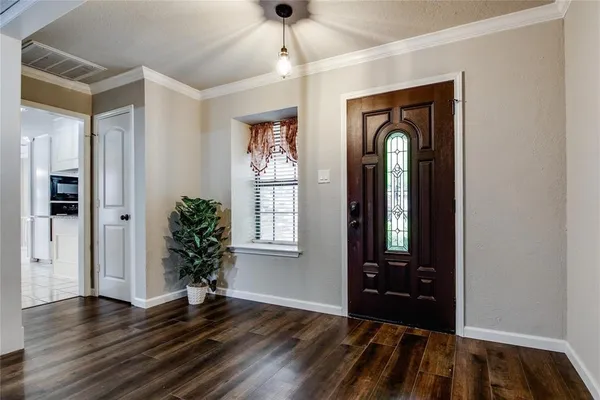 a view of empty room with wooden floor and entryway