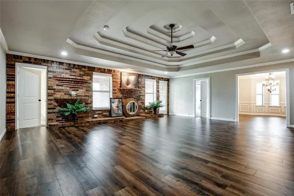 a view of a livingroom with wooden floor and a ceiling fan